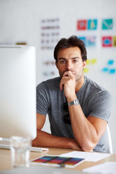 Mann plant Webseite und macht sich kreative Gedanken